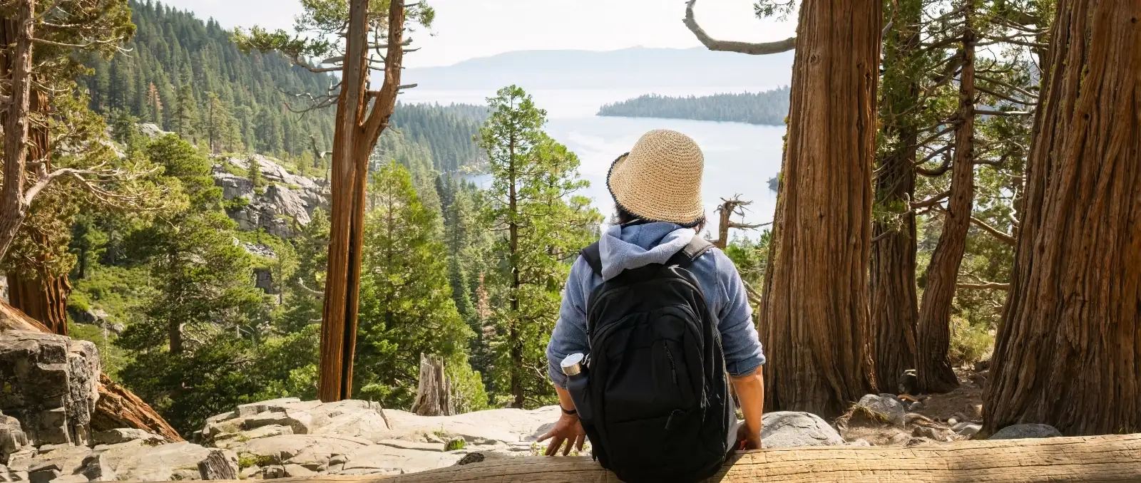 hiking sitting on cliffside enjoying view of the lake