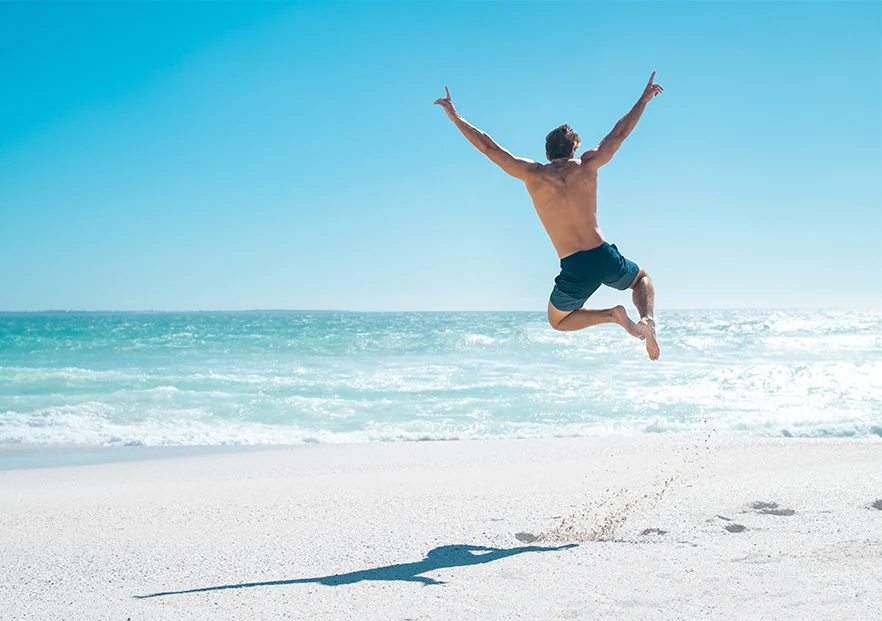 happy man jumping on the beach