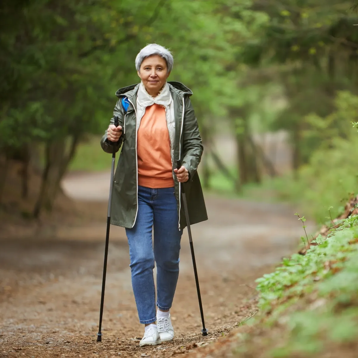 senior woman hiking on woodland trail
