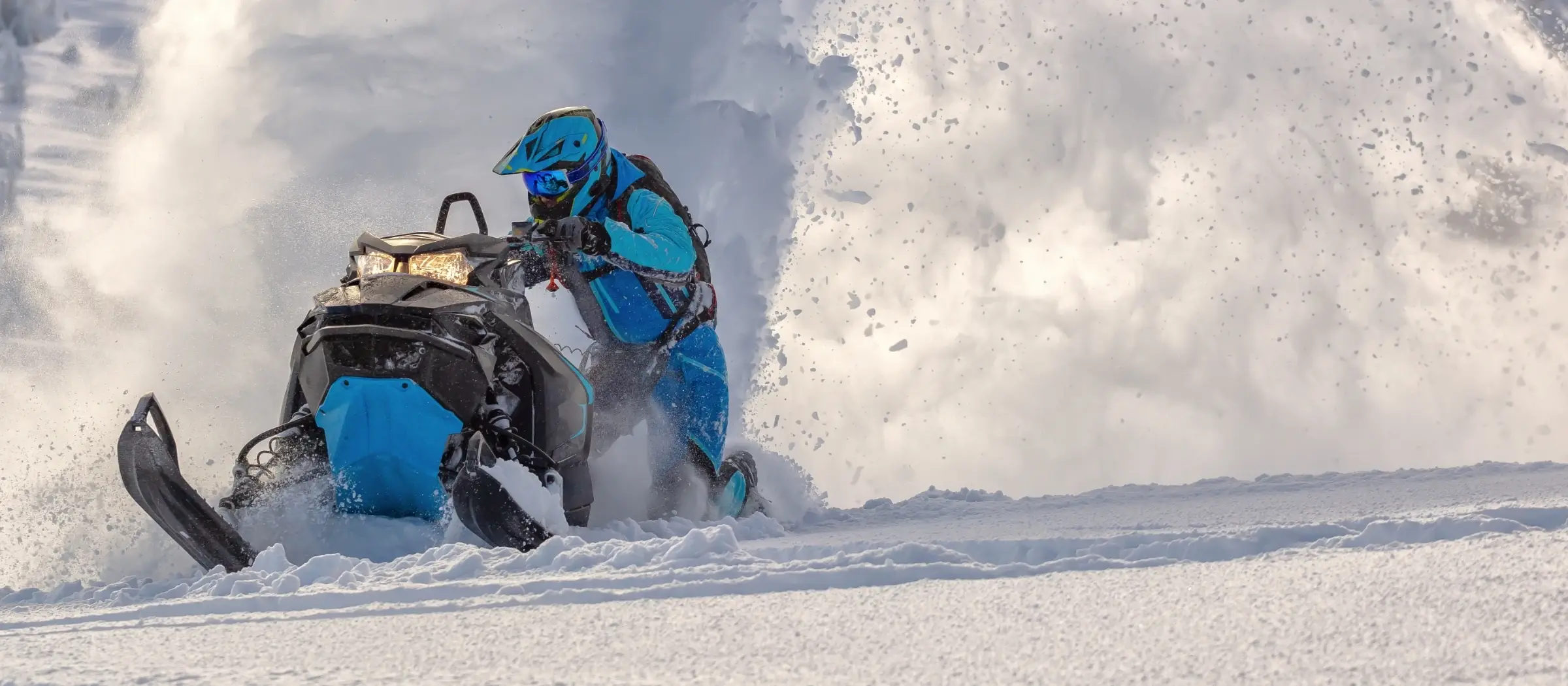 person in blue gear riding snowmobile in Tahoe