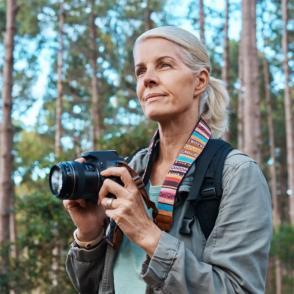 senior photographer hiking in woods